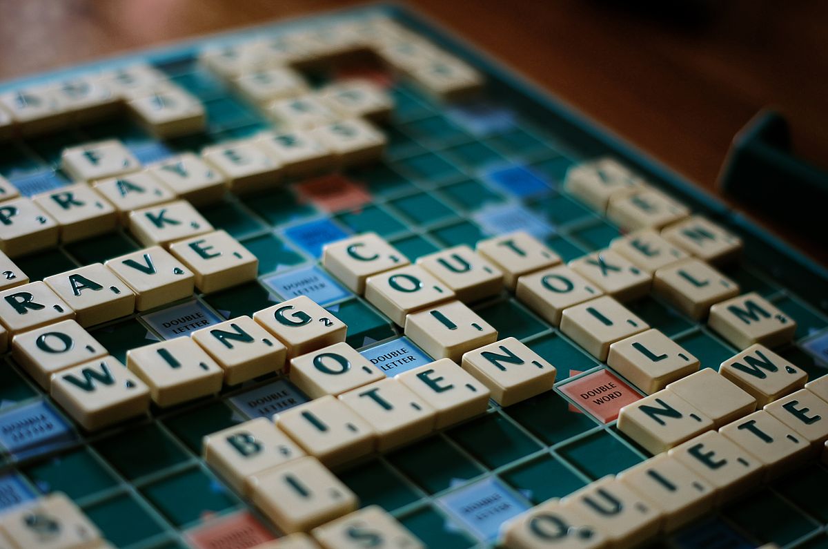 A Scrabble board with the word EXING on it.