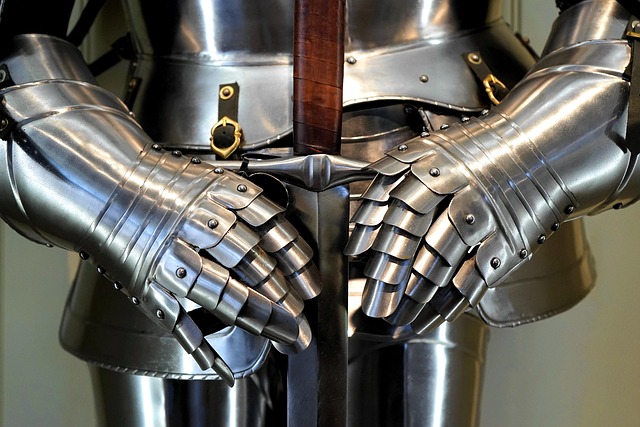 Steel gauntlets and plate armor resting on a sword handle