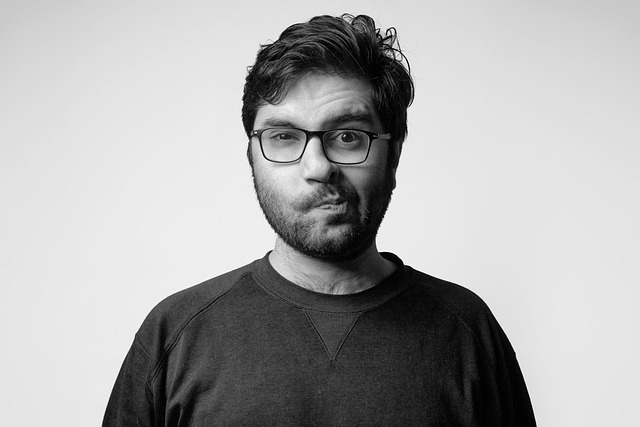 A man with glasses making a confused facial expression