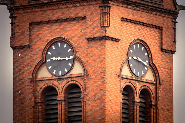 A red brick clock tower with two clock faces