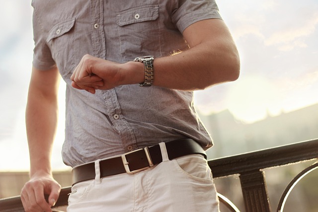 A man looking at a wristwatch on his arm