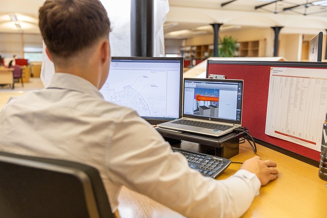 A person working at a desk with computer screens in an office