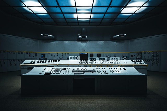 An empty industrial control room with large monitoring consoles