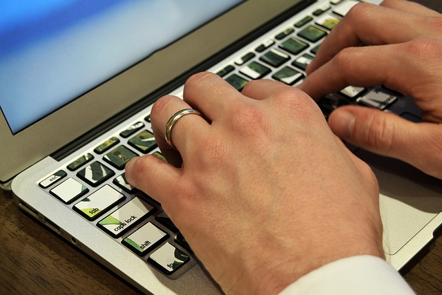 Hands typing on a laptop keyboard with patterned keys
