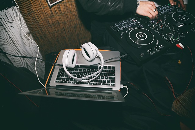A DJ controller, headphones, and a laptop used for audio production