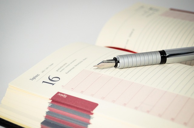 An open planner calendar with a pen resting on it