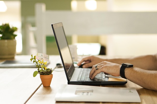 A person typing on a laptop at a desk