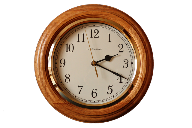 A round wooden analog wall clock showing time