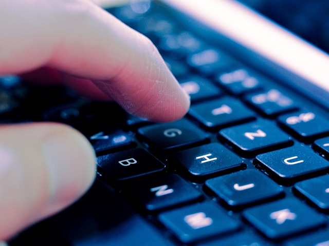 Close-up of fingers typing on a laptop keyboard