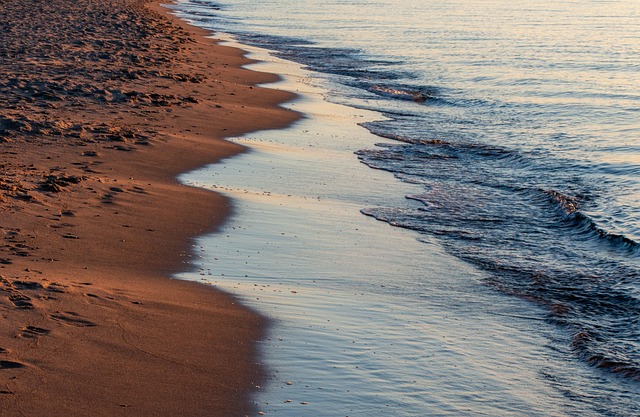 Calm ocean waves gently washing onto a sandy shoreline
