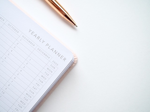A yearly planner notebook and a rose gold pen