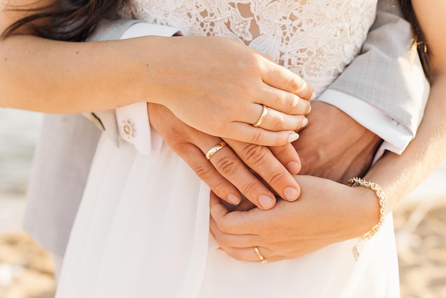 Close-up of a bride and groom embracing, showing wedding rings