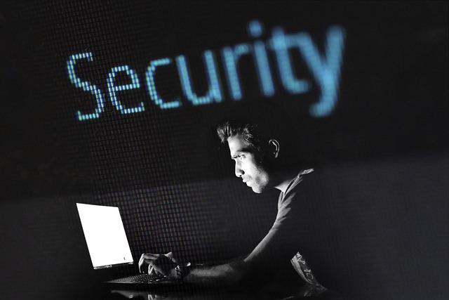 A man working on a laptop with glowing word Security above