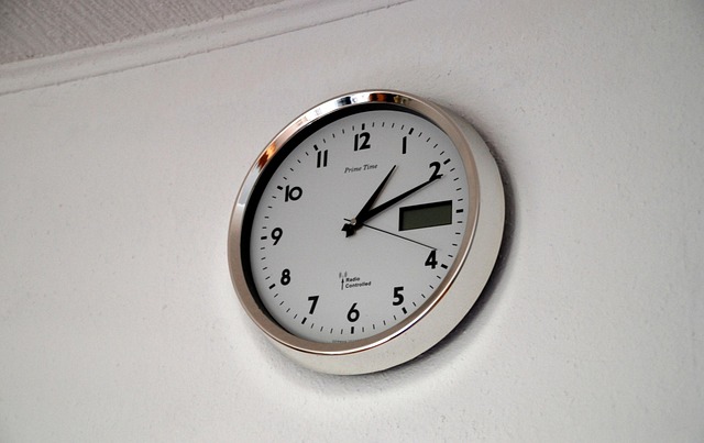 An analog wall clock mounted on a plain white wall