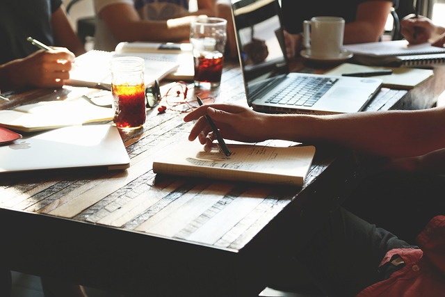 People working together at a table with laptops and notebooks