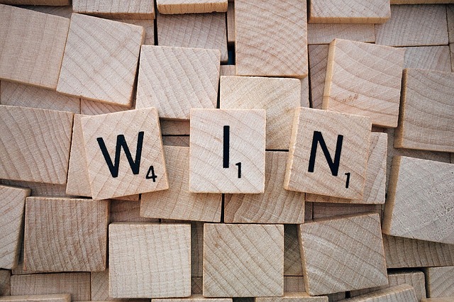 Scrabble board with the word EXULT placed to block opponent's access to triple word score (Exing Scrabble Word)