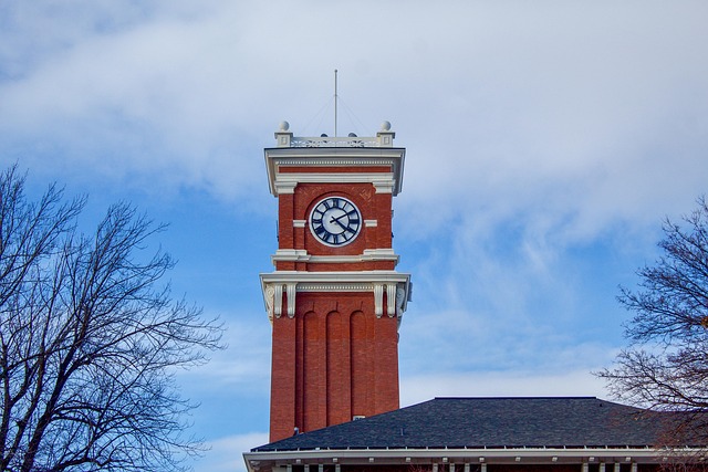A tall brick clock tower against a blue sky