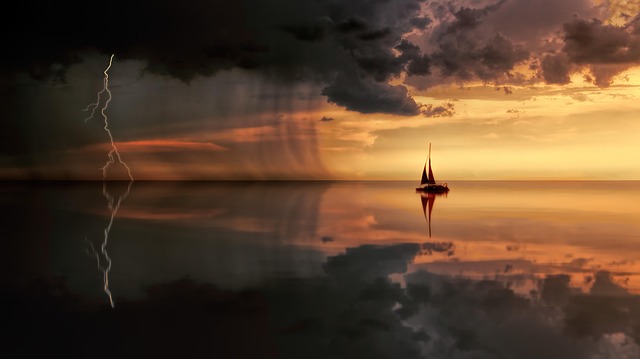 A sailboat on calm water under a storm with lightning