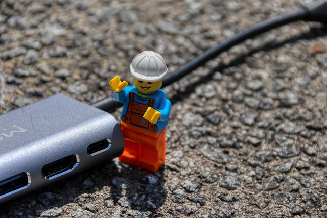 A Lego construction worker figure standing next to a USB hub