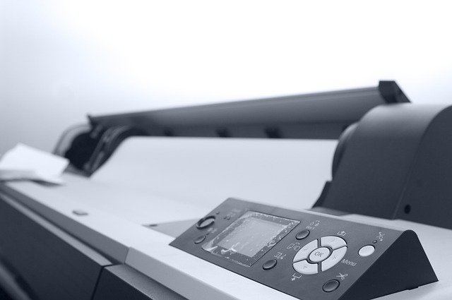 A large format office printer with a control panel and buttons