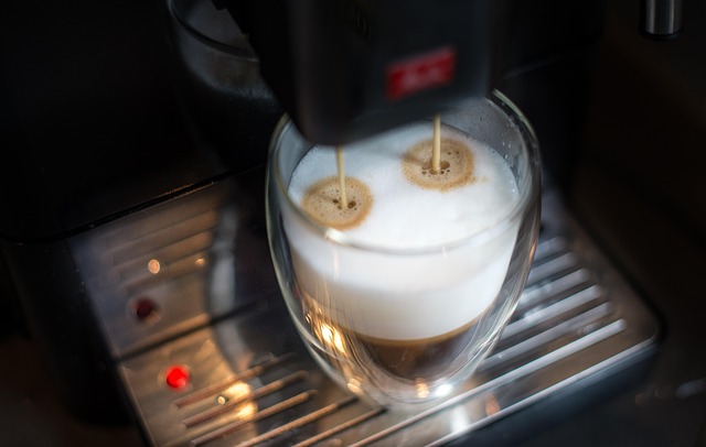 An automatic coffee machine pouring espresso into frothed milk