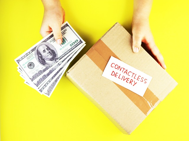 Hands holding US dollar bills and a contactless delivery package
