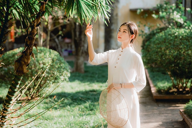 A woman in traditional white attire standing outdoors in a garden